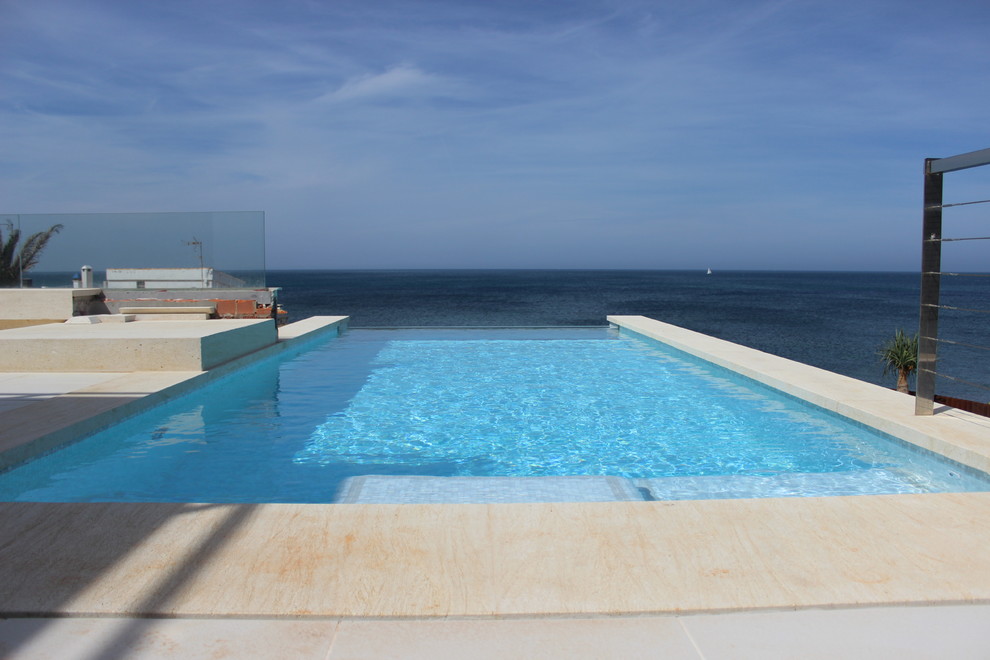 This is an example of a mid-sized mediterranean rooftop rectangular infinity pool in Alicante-Costa Blanca with a pool house.