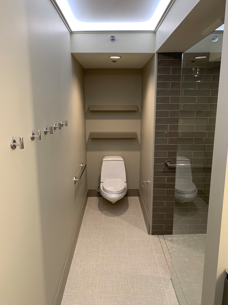 Inspiration for a mid-sized contemporary master bathroom in Seattle with open cabinets, grey cabinets, a curbless shower, a wall-mount toilet, grey walls, porcelain floors, an integrated sink, glass benchtops, beige floor, an open shower and green benchtops.