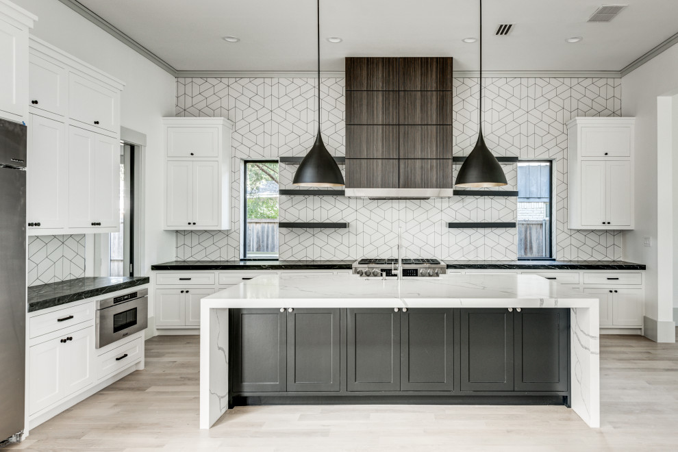 Example of a transitional l-shaped light wood floor and white floor open concept kitchen design in Dallas with a farmhouse sink, shaker cabinets, white cabinets, quartz countertops, white backsplash, ceramic backsplash, stainless steel appliances, an island and white countertops