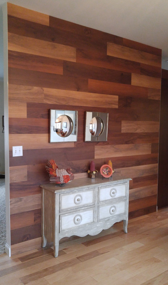 Example of a mid-sized light wood floor foyer design with brown walls