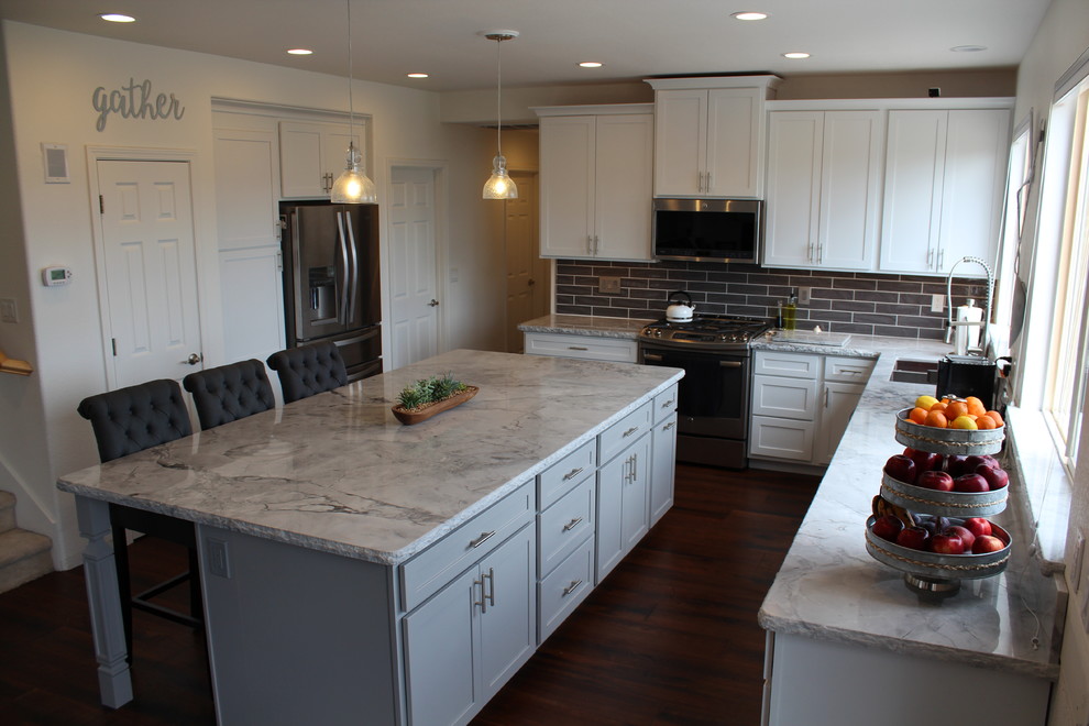 Open concept kitchen - mid-sized transitional l-shaped medium tone wood floor and brown floor open concept kitchen idea with an undermount sink, marble countertops, gray backsplash, ceramic backsplash, stainless steel appliances and an island