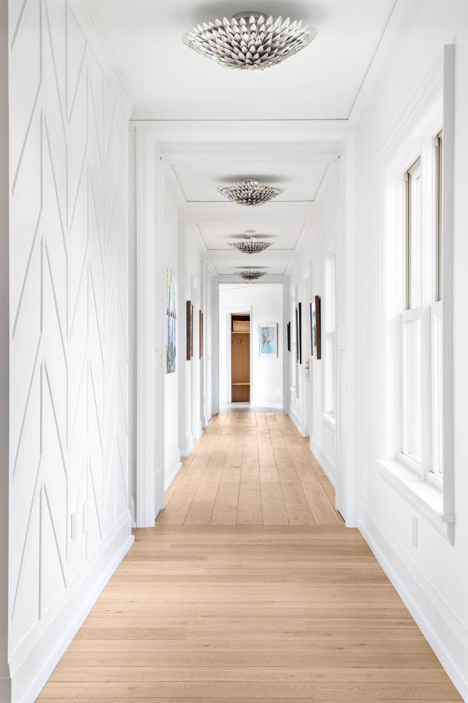 Idée de décoration pour un très grand couloir marin avec un mur blanc, un sol marron, du lambris et un sol en bois brun.
