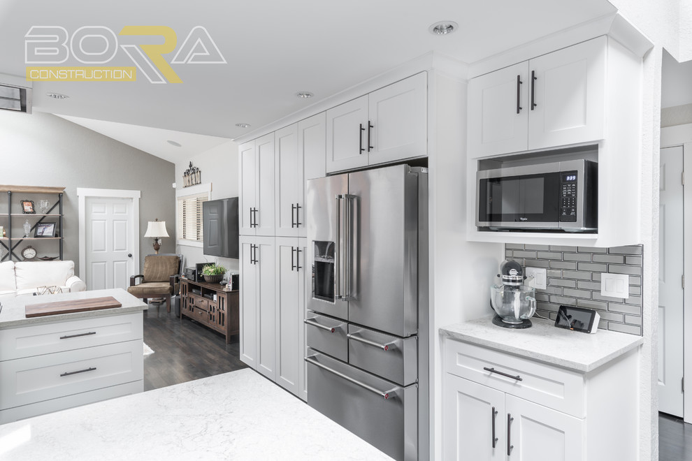 Inspiration for a mid-sized transitional u-shaped dark wood floor and brown floor eat-in kitchen remodel with an undermount sink, recessed-panel cabinets, white cabinets, wood countertops, metallic backsplash, ceramic backsplash, stainless steel appliances and a peninsula