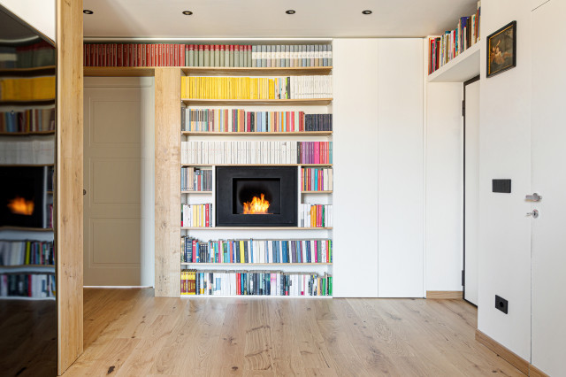 Ingresso con libreria e camino skandinavisk-dagligstue