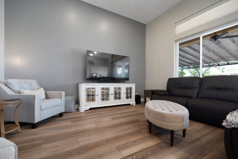 Aménagement d'un grand salon moderne fermé avec une salle de réception, un mur gris, un sol en vinyl, un téléviseur indépendant et un sol marron.