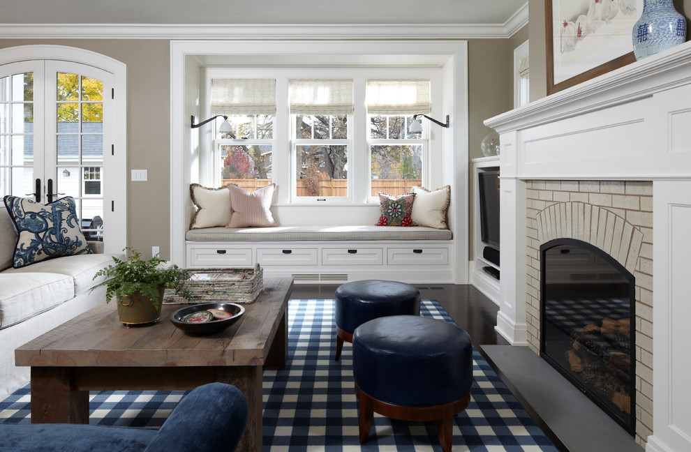 This is an example of a living room in Minneapolis with grey walls, a standard fireplace and a brick fireplace surround.