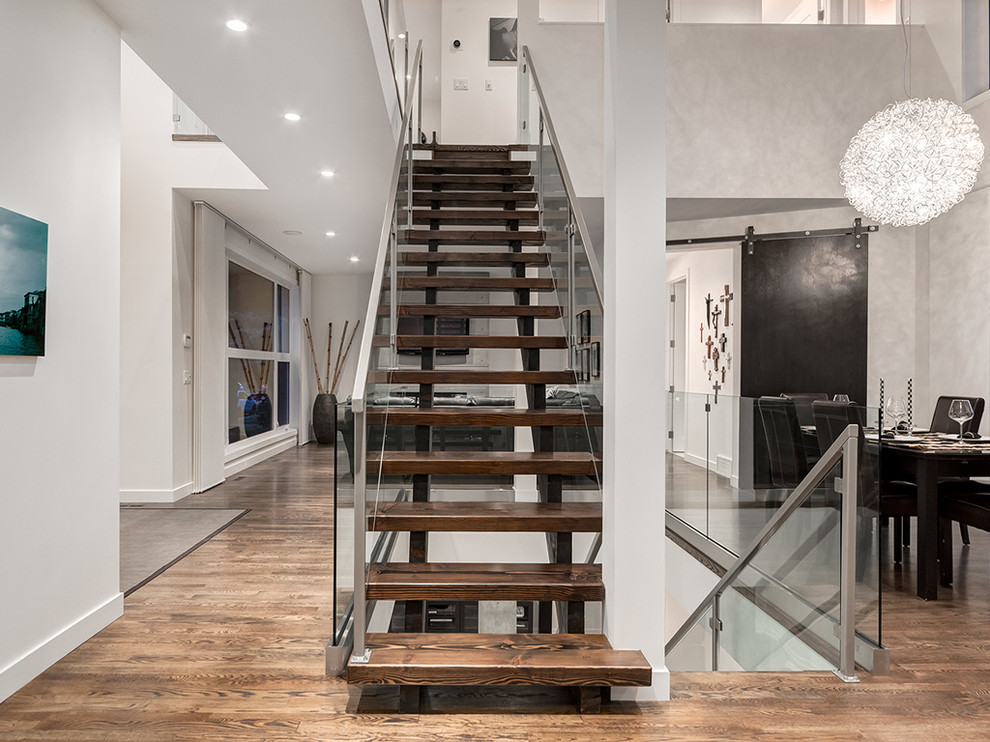 This is an example of a modern wood straight staircase in Toronto with open risers.