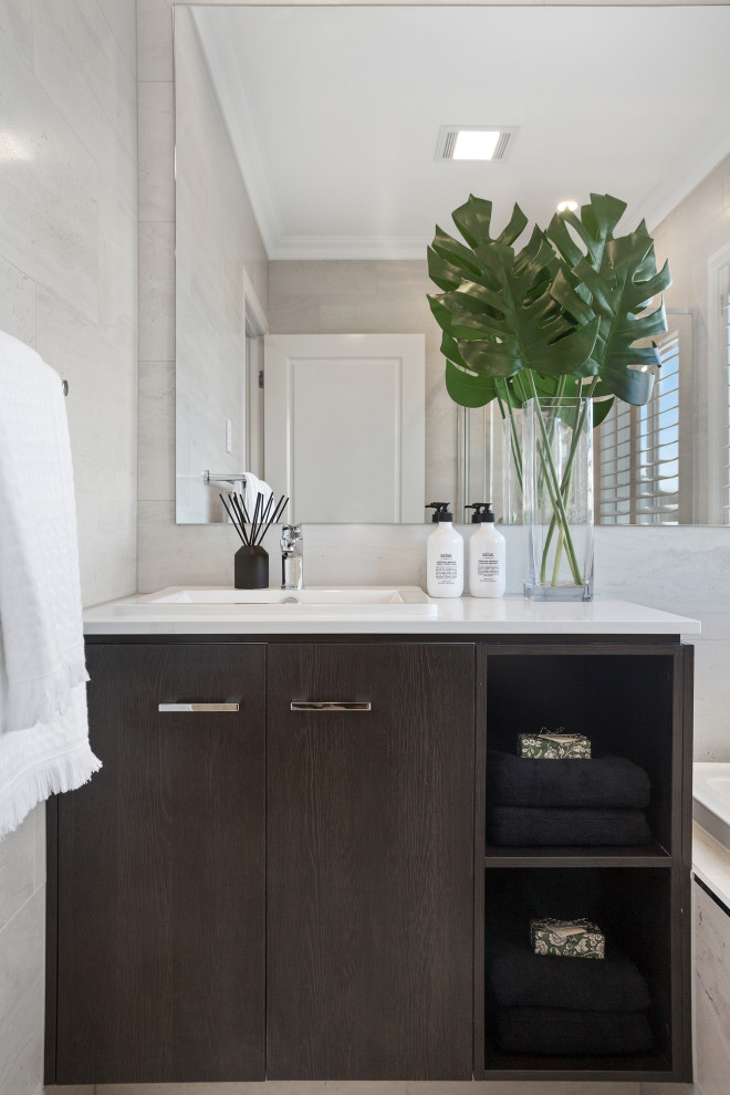 Mid-sized contemporary 3/4 bathroom in Gold Coast - Tweed with flat-panel cabinets, dark wood cabinets, gray tile, porcelain tile, a drop-in sink, white benchtops, a single vanity and a built-in vanity.