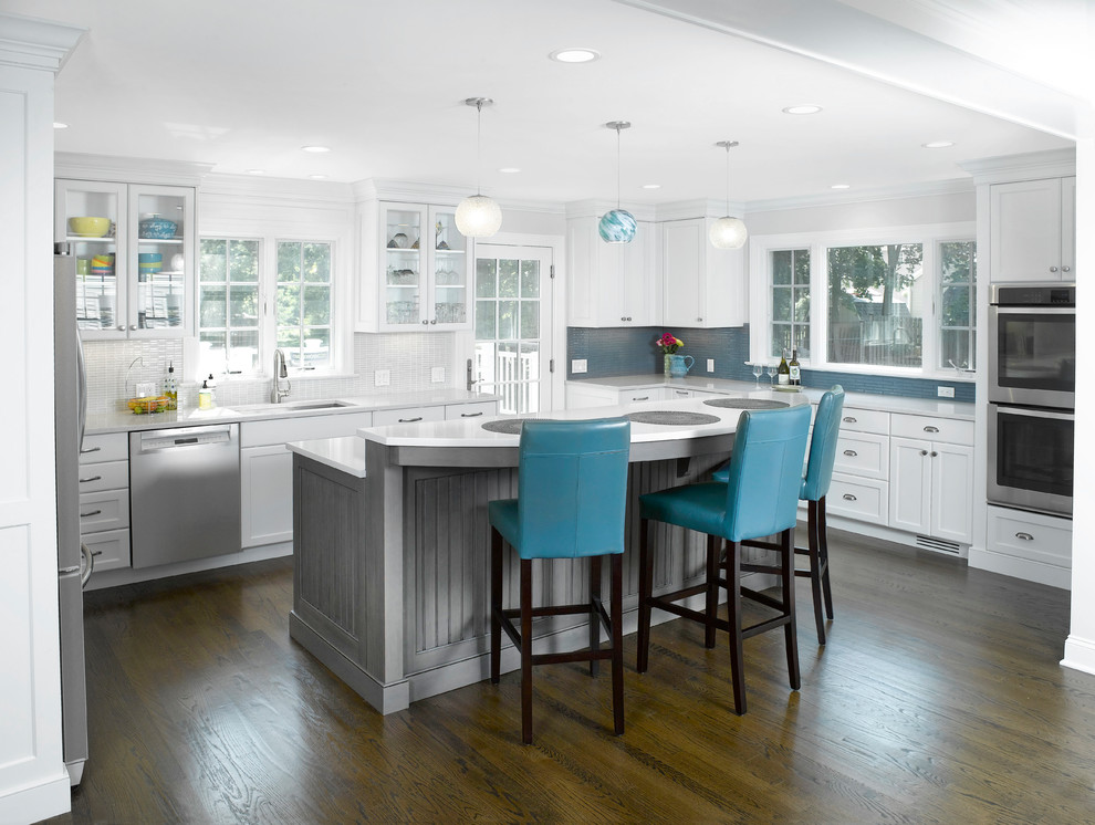Transitional u-shaped dark wood floor and brown floor kitchen photo in New York with an undermount sink, shaker cabinets, white cabinets, stainless steel appliances and an island