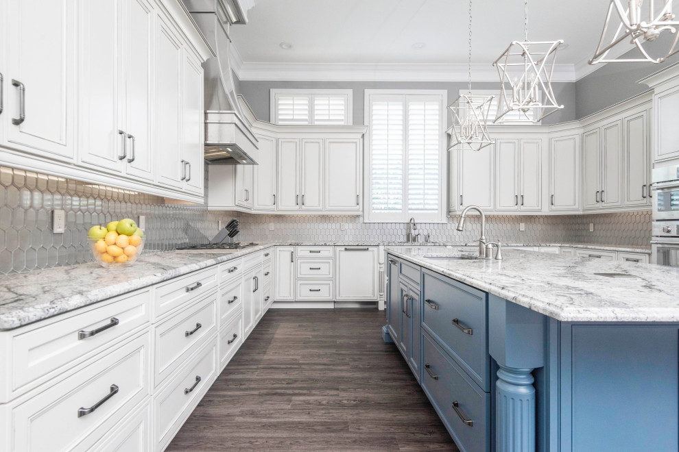 Inspiration for a large transitional u-shaped laminate floor and multicolored floor kitchen remodel in Orlando with an undermount sink, recessed-panel cabinets, white cabinets, granite countertops, metallic backsplash, glass tile backsplash, paneled appliances, an island and gray countertops