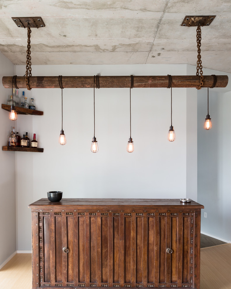 Mid-sized industrial single-wall home bar in Nashville with no sink, dark wood cabinets, wood benchtops, bamboo floors, beige floor and brown benchtop.