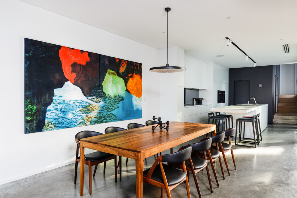 This is an example of a contemporary kitchen/dining combo in Perth with white walls, concrete floors and grey floor.