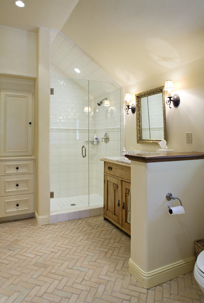 This is an example of a country bathroom in Other with a corner shower and brick floors.