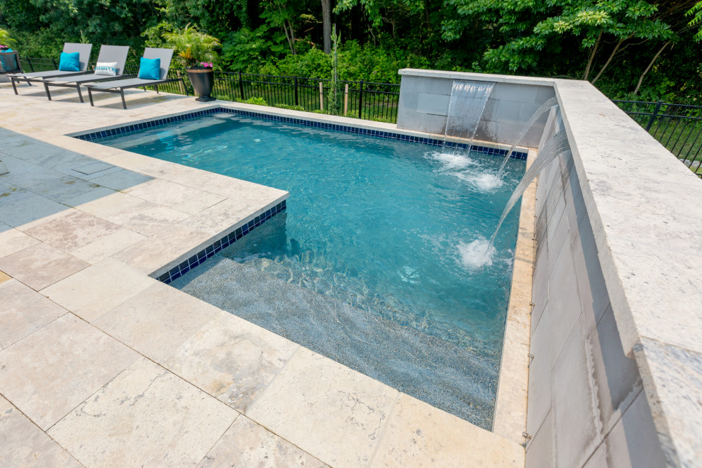 Inspiration for a small contemporary back custom shaped swimming pool in Other with natural stone paving.
