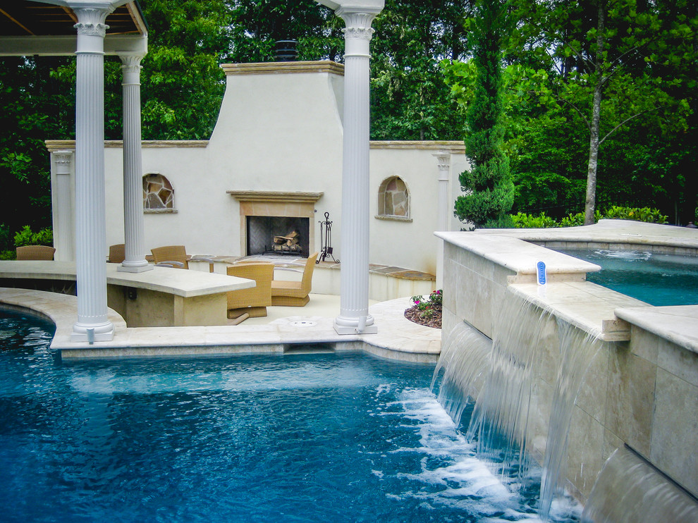 This is an example of a large mediterranean backyard custom-shaped pool in Atlanta with a water feature and concrete slab.