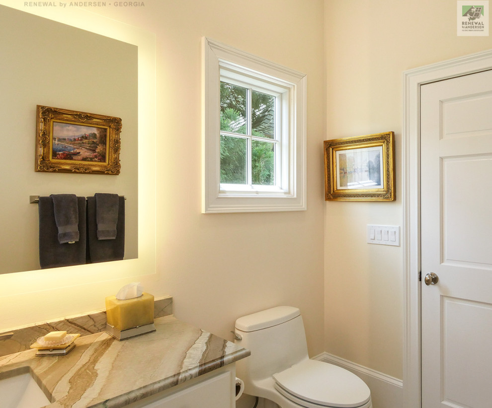 Small bathroom in Atlanta with white cabinets, a one-piece toilet, yellow walls, an undermount sink, marble benchtops, beige benchtops, a single vanity, a built-in vanity and vaulted.