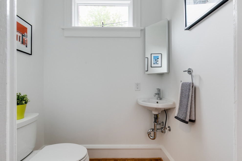 Inspiration för ett mellanstort vintage toalett, med vita väggar, ljust trägolv och ett väggmonterat handfat