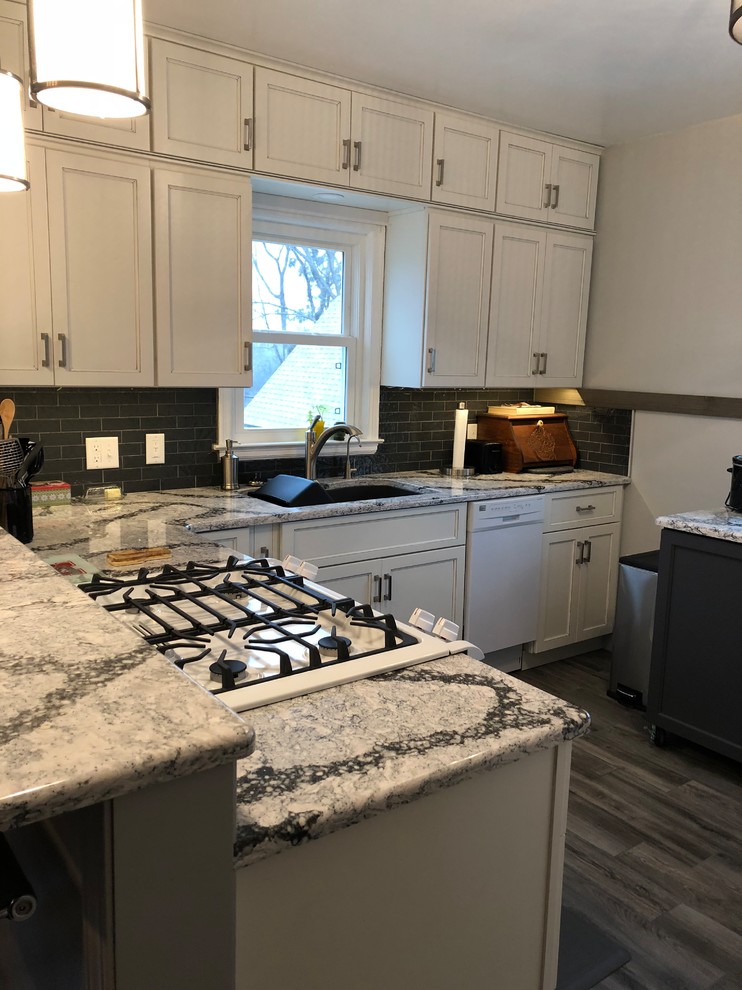 Inspiration for a small transitional l-shaped laminate floor and gray floor eat-in kitchen remodel with an undermount sink, flat-panel cabinets, white cabinets, quartz countertops, gray backsplash, subway tile backsplash, white appliances and white countertops