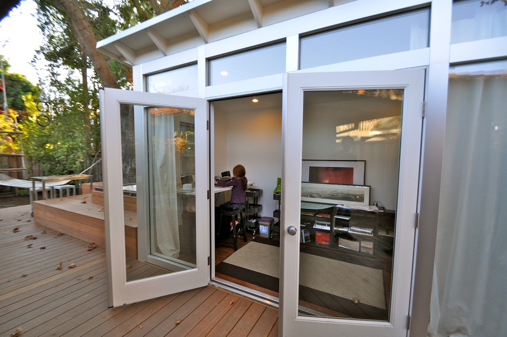 Photo of a small modern enclosed family room in San Francisco with white walls and laminate floors.