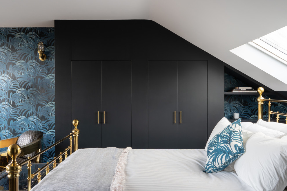 Mid-sized eclectic guest bedroom in London with blue walls and wallpaper.