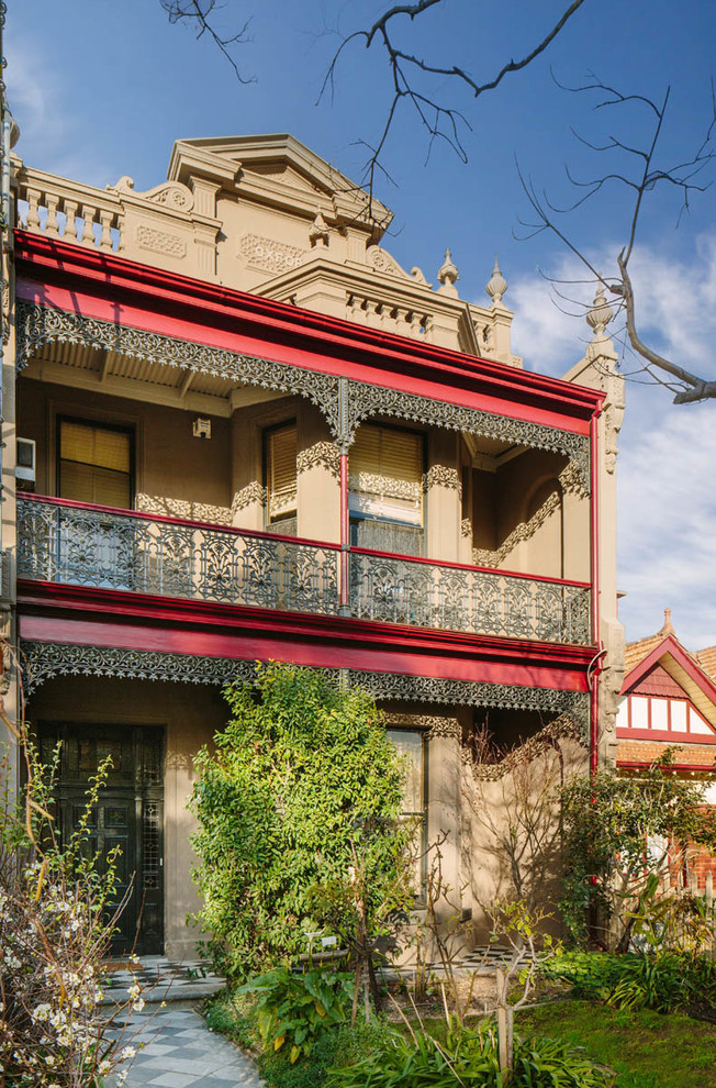 Large traditional two-storey stucco beige exterior in Melbourne with a gable roof.