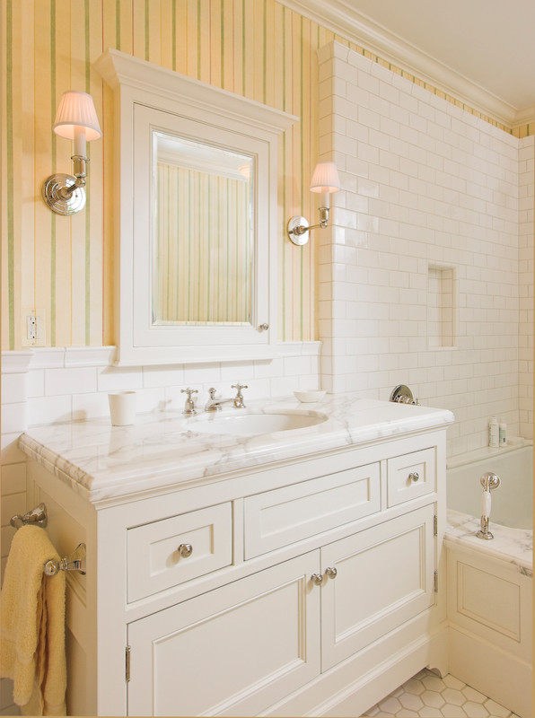 Inspiration for a large traditional bathroom in New York with an undermount sink, furniture-like cabinets, white cabinets, marble benchtops, an undermount tub, a shower/bathtub combo, a two-piece toilet, yellow tile, mosaic tile, yellow walls and mosaic tile floors.