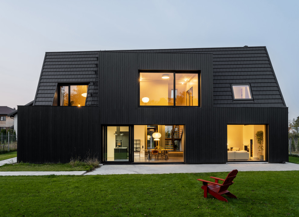Стильный дизайн: двухэтажный, черный частный загородный дом в современном стиле с черной крышей - последний тренд