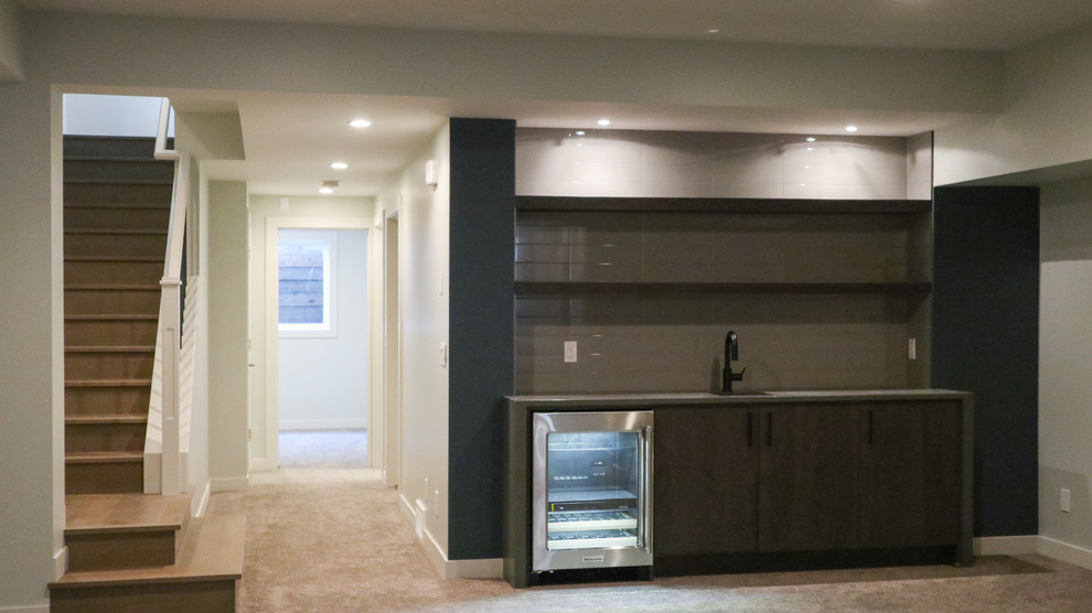 Large transitional underground carpeted and gray floor basement photo in Calgary with gray walls