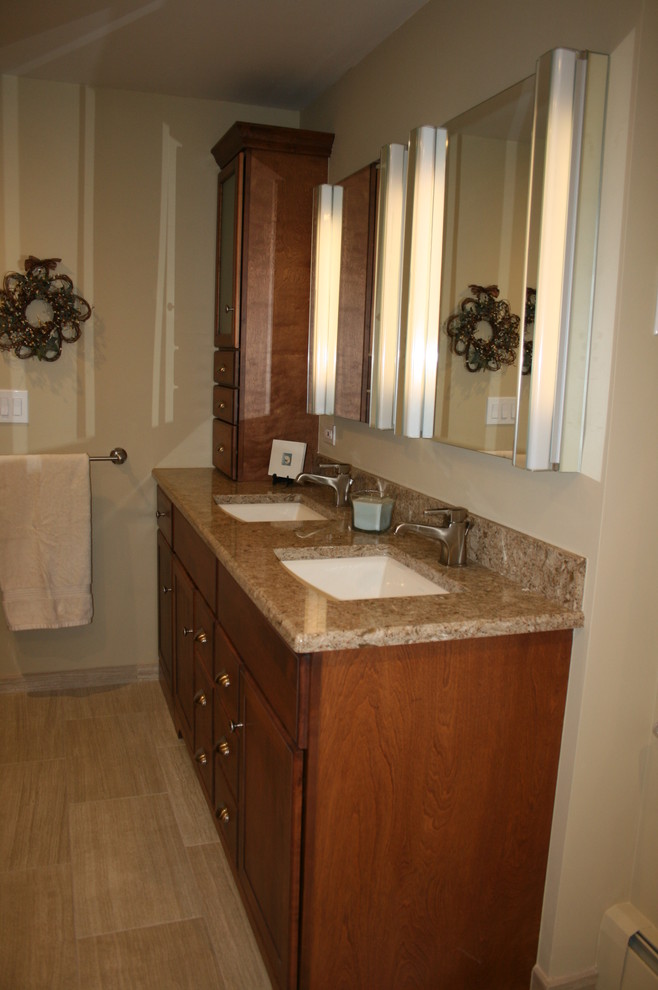 Inspiration for a small transitional kids' beige tile and porcelain tile porcelain tile drop-in bathtub remodel in Chicago with raised-panel cabinets, medium tone wood cabinets, a one-piece toilet, beige walls, an undermount sink and quartz countertops