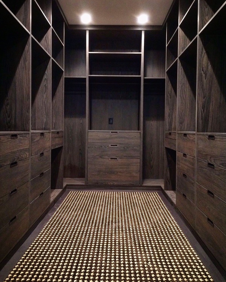 Photo of a large modern gender-neutral walk-in wardrobe in Houston with carpet.