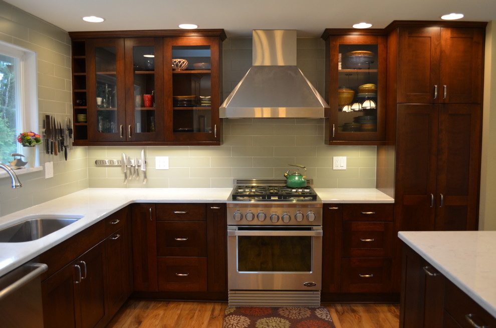 Open concept kitchen - mid-sized transitional l-shaped medium tone wood floor and brown floor open concept kitchen idea in Seattle with an undermount sink, shaker cabinets, dark wood cabinets, quartz countertops, stainless steel appliances, an island, gray backsplash and subway tile backsplash