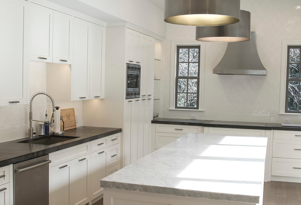 Large transitional u-shaped medium tone wood floor eat-in kitchen photo in Austin with an undermount sink, shaker cabinets, white cabinets, marble countertops, white backsplash, ceramic backsplash, stainless steel appliances and an island