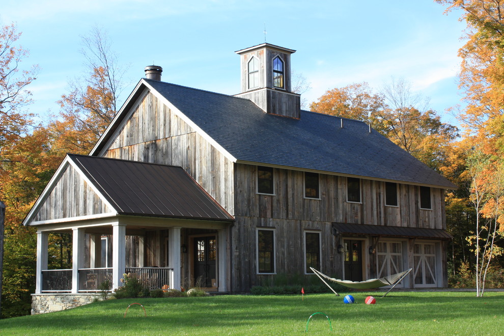 Photo of a mid-sized country two-storey exterior in Burlington with wood siding.