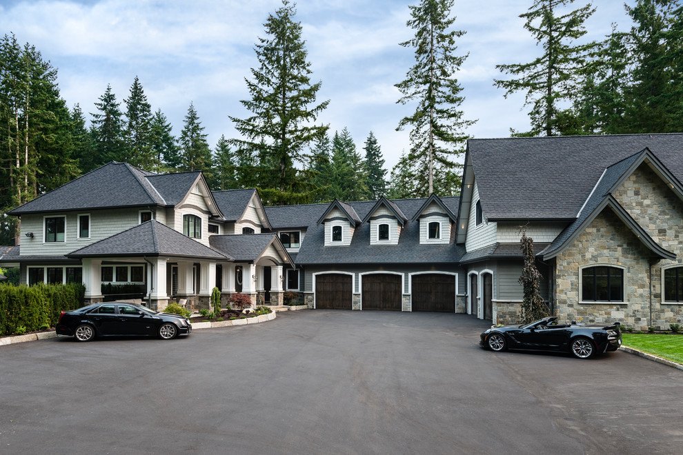 Expansive traditional three-storey grey house exterior in Vancouver with mixed siding, a gable roof and a shingle roof.