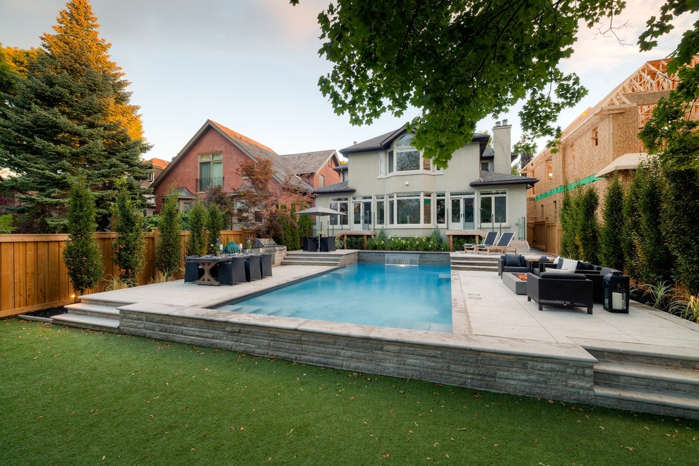 Inspiration for a large contemporary backyard rectangular lap pool in Toronto with stamped concrete.