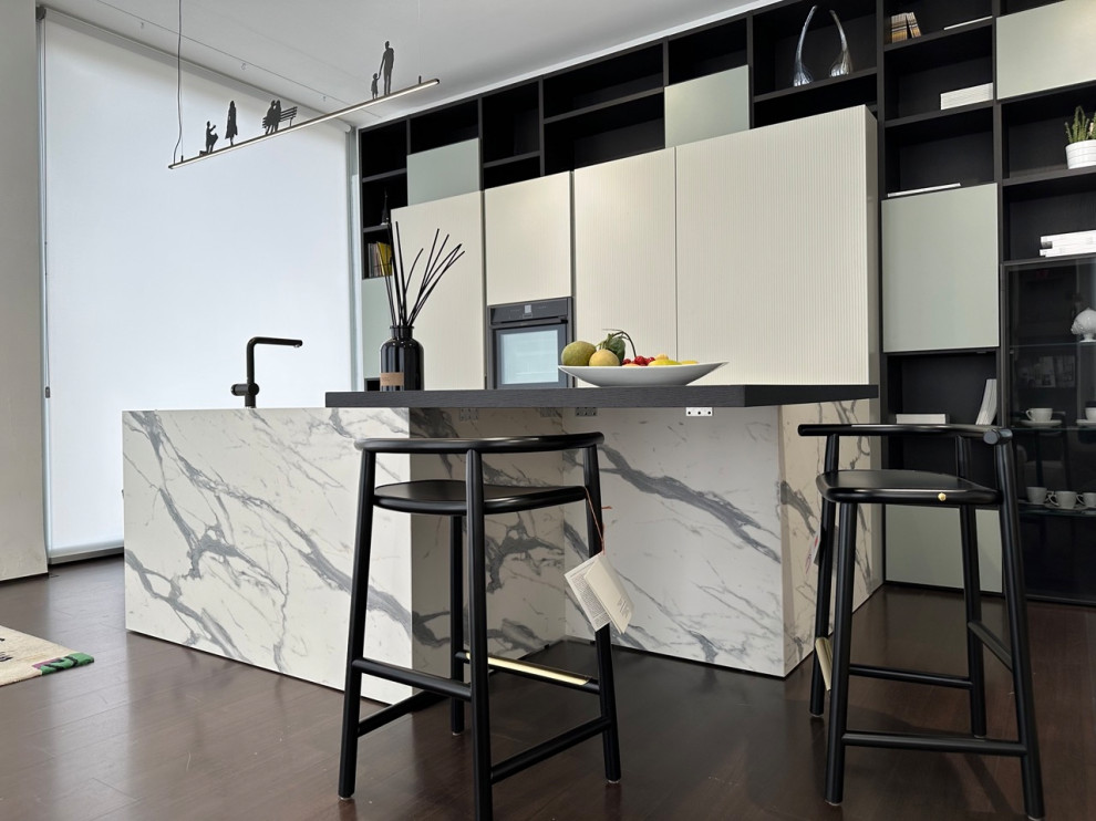 Modern inredning av ett stort flerfärgad flerfärgat kök, med en integrerad diskho, luckor med glaspanel, vita skåp, laminatbänkskiva, svarta vitvaror, mörkt trägolv och brunt golv