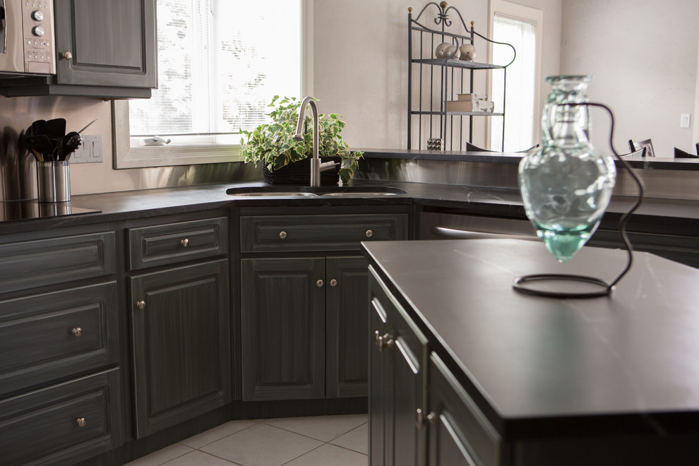 Enclosed kitchen - mid-sized transitional u-shaped ceramic tile enclosed kitchen idea in Toronto with an undermount sink, raised-panel cabinets, blue cabinets, soapstone countertops, metallic backsplash and an island
