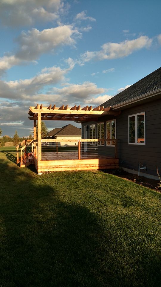 Example of a large mountain style deck design with a pergola