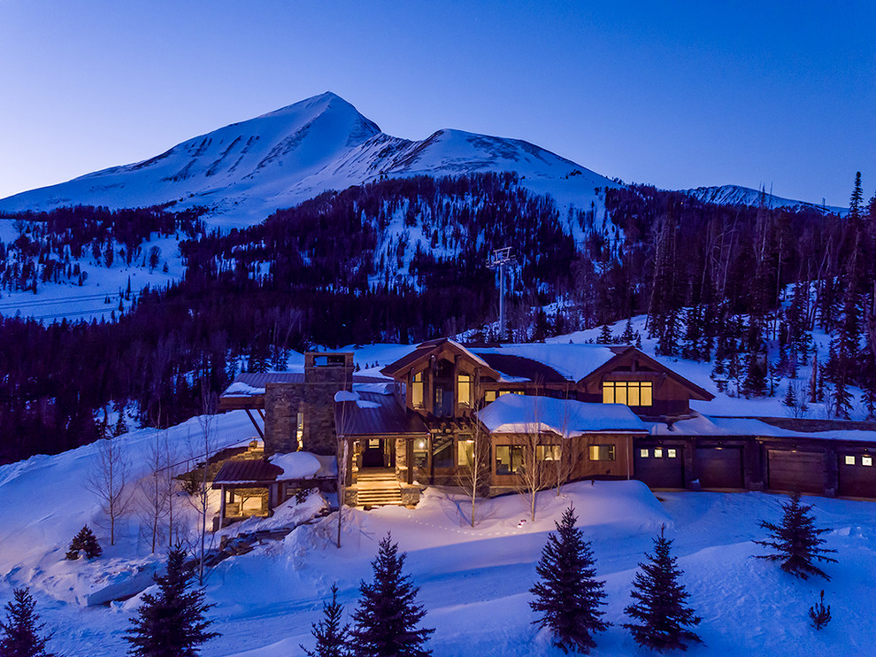 Mountain Peek - Example of a large mountain style brown split-level wood house exterior design with a shed roof and a mixed material roof