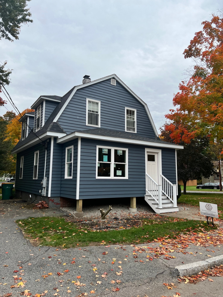 Mid-sized elegant blue two-story vinyl and clapboard house exterior photo in Providence with a gambrel roof, a shingle roof and a black roof