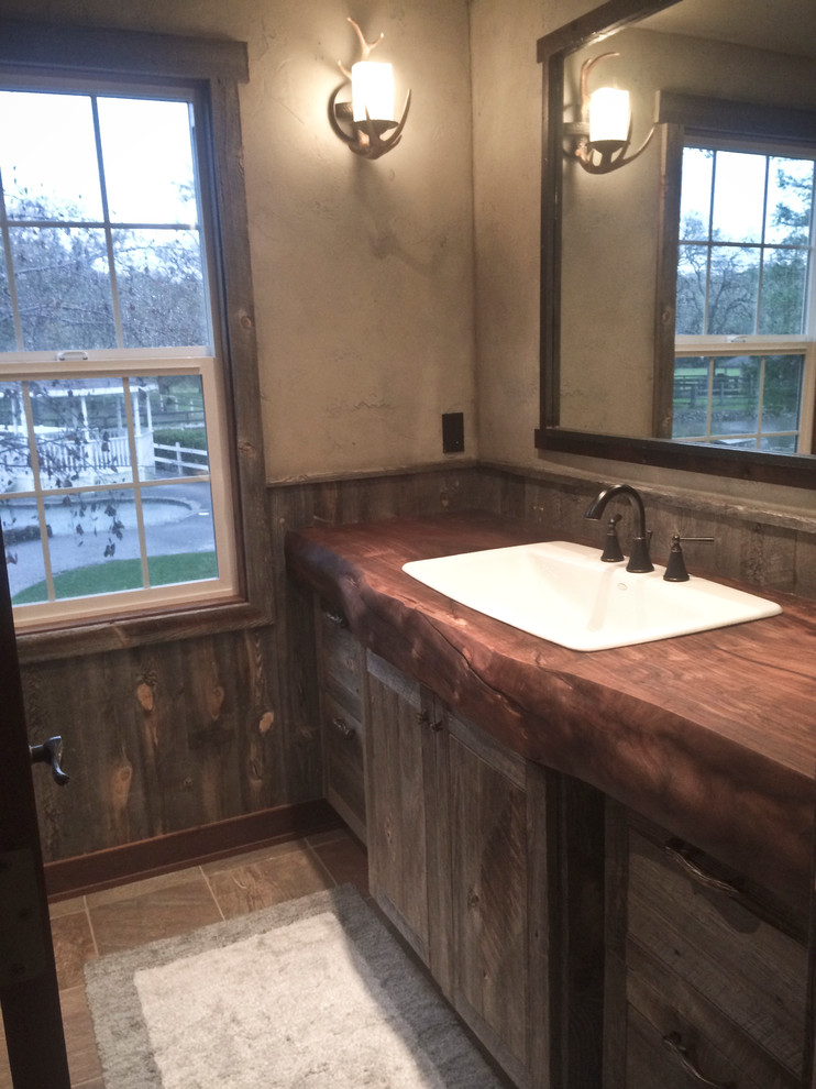 Design ideas for a small country 3/4 bathroom in Other with distressed cabinets, wood benchtops, slate floors, brown tile, beige walls, recessed-panel cabinets, a drop-in sink and brown floor.