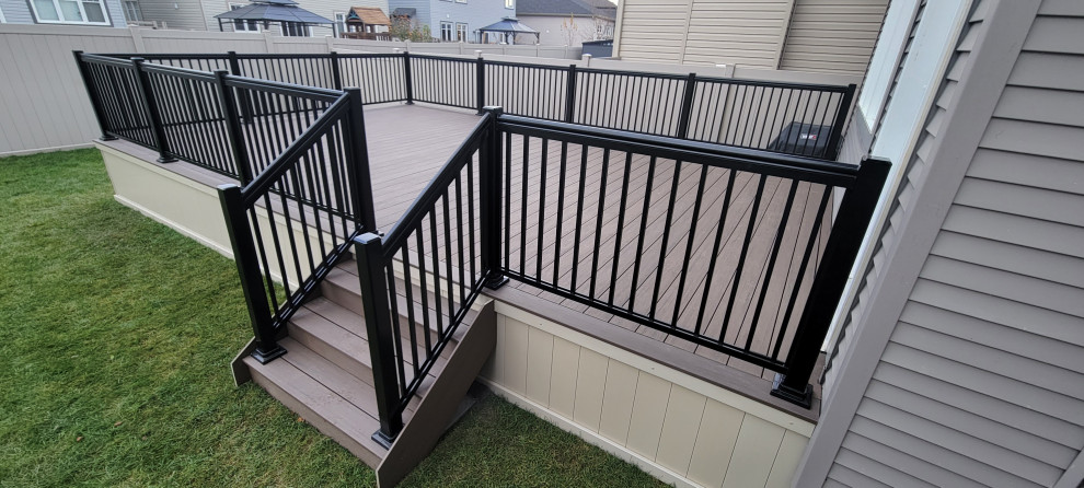 Inspiration for a large modern back ground level metal railing terrace in Ottawa with skirting and no cover.