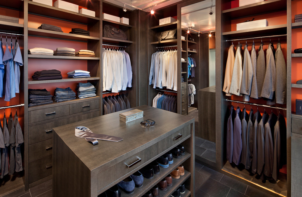 Design ideas for a large contemporary men's walk-in wardrobe in New York with flat-panel cabinets, dark wood cabinets and slate floors.