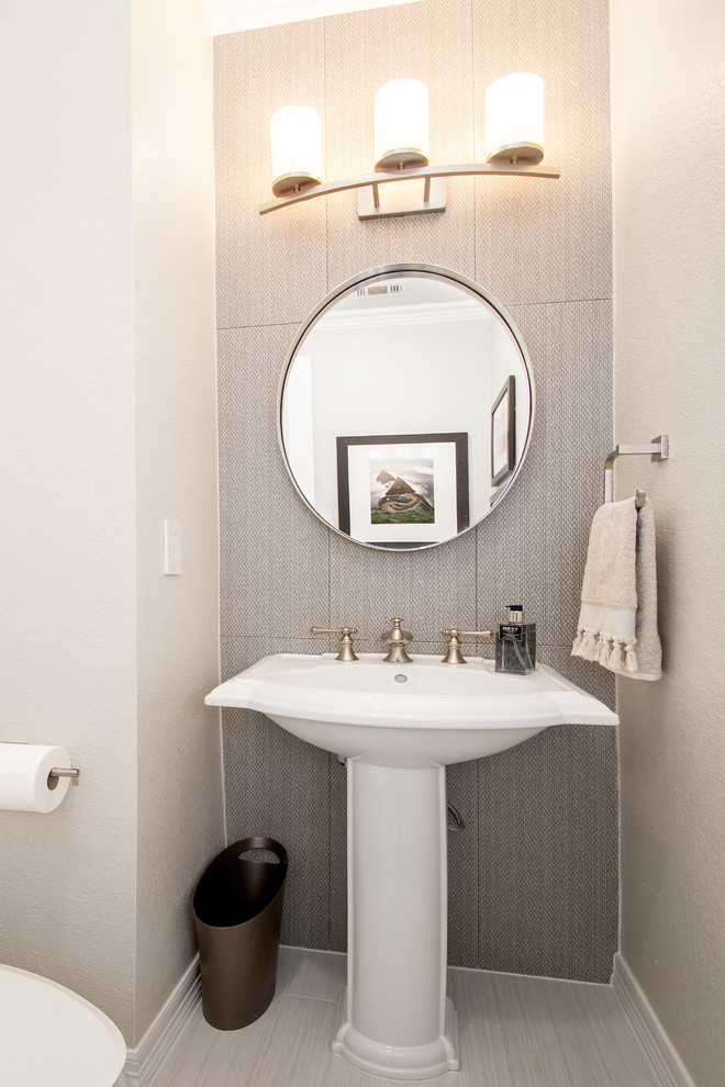 Inspiration for a small transitional gray tile and ceramic tile porcelain tile and gray floor powder room remodel in Dallas with a two-piece toilet, gray walls and a pedestal sink