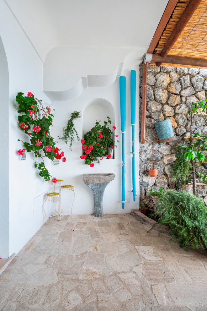 На фото: пергола во дворе частного дома среднего размера на переднем дворе в средиземноморском стиле с покрытием из каменной брусчатки с