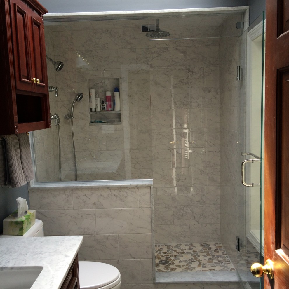 Inspiration for a modern master bathroom in Boston with raised-panel cabinets, dark wood cabinets, a corner shower, a two-piece toilet, white tile, porcelain tile, grey walls, slate floors, an undermount sink and marble benchtops.