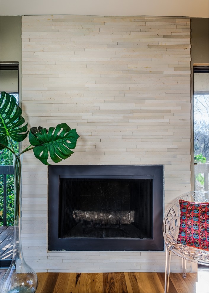 Inspiration for a small contemporary open concept family room in Austin with beige walls, medium hardwood floors, a standard fireplace and a stone fireplace surround.
