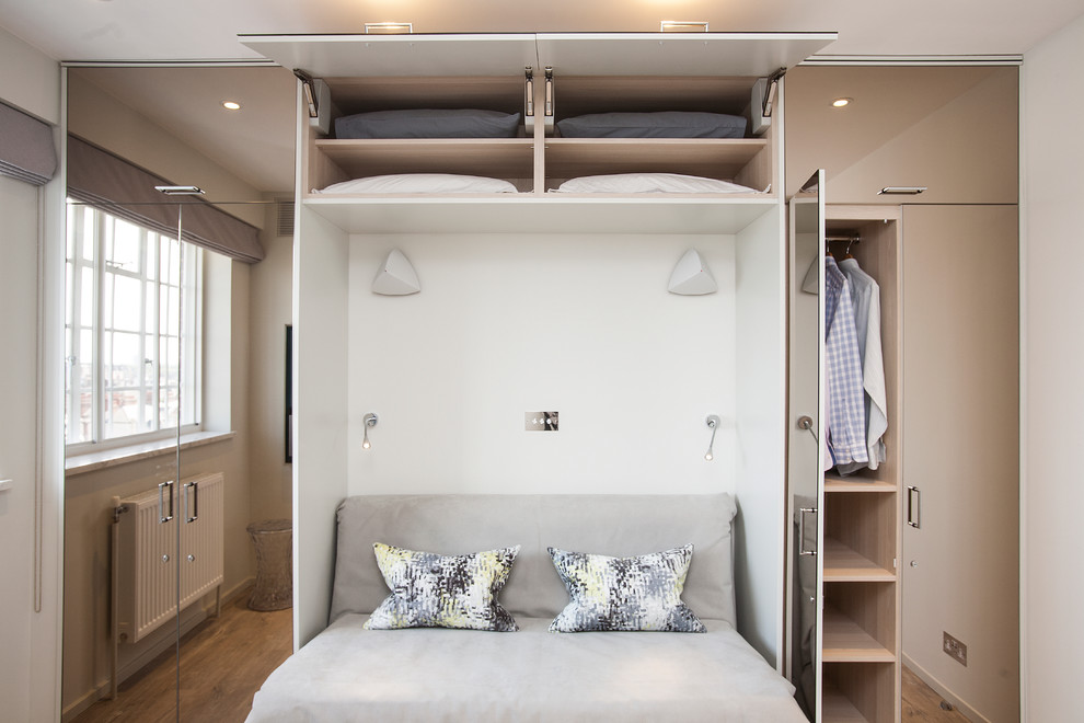 This is an example of a small contemporary gender-neutral storage and wardrobe in London with vinyl floors, beige floor and flat-panel cabinets.
