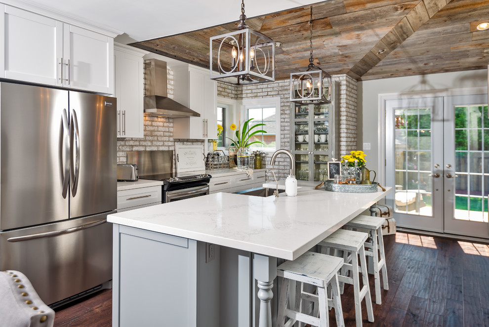 Design ideas for a country galley eat-in kitchen in Toronto with a farmhouse sink, shaker cabinets, white cabinets, stainless steel appliances, medium hardwood floors and with island.