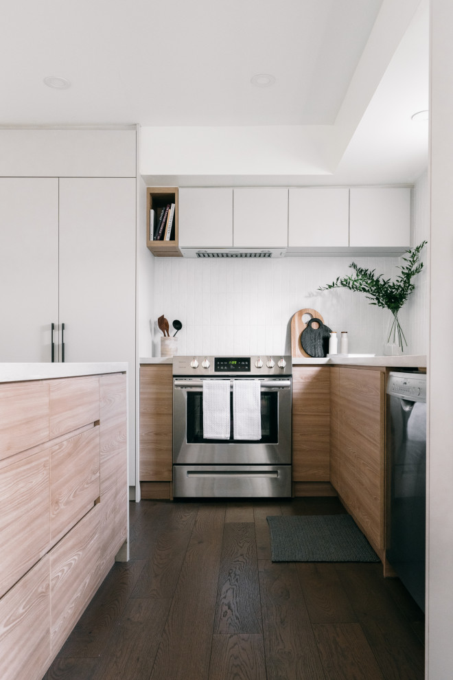Design ideas for a small l-shaped eat-in kitchen in Toronto with an undermount sink, flat-panel cabinets, light wood cabinets, quartz benchtops, white splashback, ceramic splashback, stainless steel appliances, dark hardwood floors, with island, brown floor and beige benchtop.